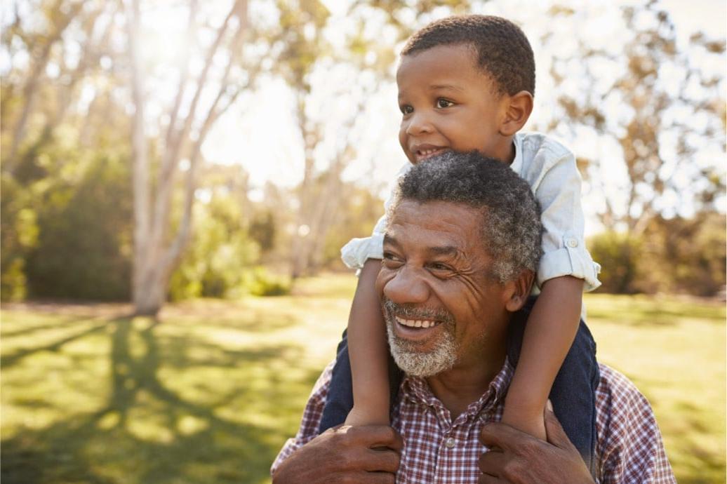 A picture of a happy man and child on his shoulder